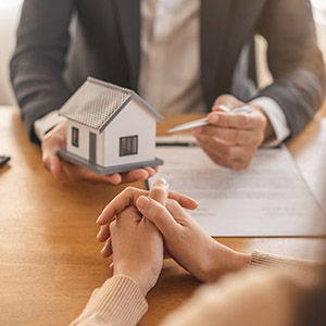 Wilmington Real Estate Law: A legal professional presenting a small house model to a homebuyer.